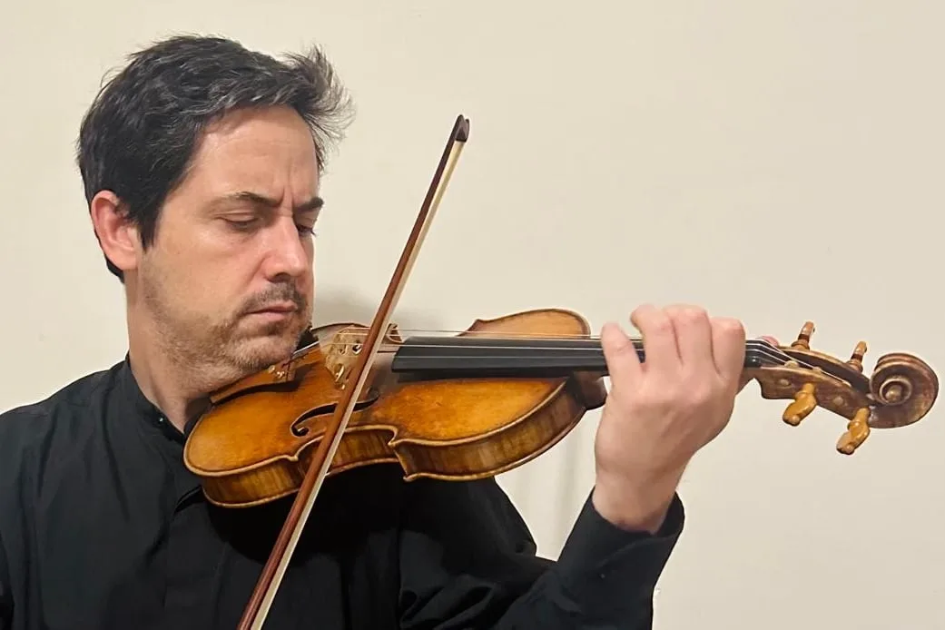 Freddy Varela Montero con violín en mano, ensayando con músicos de la Camerata Bariloche